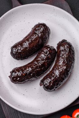 Lezzetli siyah kan sosisi veya siyah beton arka planda ızgara baharat ve otlu kara puding.