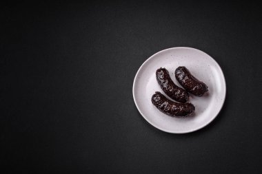 Lezzetli siyah kan sosisi veya siyah beton arka planda ızgara baharat ve otlu kara puding.