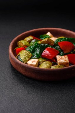 Lezzetli taze kabak salatası, peynir, tatlı biber, baharatlı ıspanak ve çimento kaplı seramik tabakta otlar.