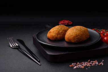 Lezzetli fırınlanmış pirzola, baharatlar, tuz ve otlarla kaplanmış koyu beton bir arka planda.