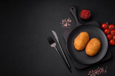 Lezzetli fırınlanmış pirzola, baharatlar, tuz ve otlarla kaplanmış koyu beton bir arka planda.