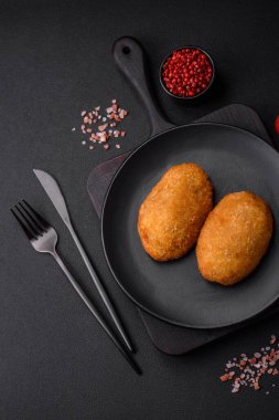 Lezzetli fırınlanmış pirzola, baharatlar, tuz ve otlarla kaplanmış koyu beton bir arka planda.