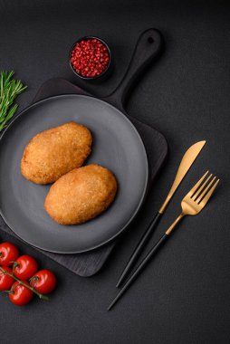 Lezzetli fırınlanmış pirzola, baharatlar, tuz ve otlarla kaplanmış koyu beton bir arka planda.