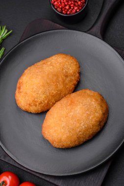 Lezzetli fırınlanmış pirzola, baharatlar, tuz ve otlarla kaplanmış koyu beton bir arka planda.