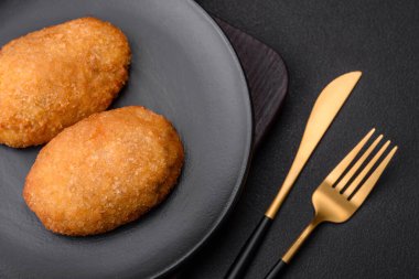 Lezzetli fırınlanmış pirzola, baharatlar, tuz ve otlarla kaplanmış koyu beton bir arka planda.