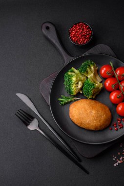 Lezzetli fırınlanmış pirzola, baharatlar, tuz ve otlarla kaplanmış koyu beton bir arka planda.