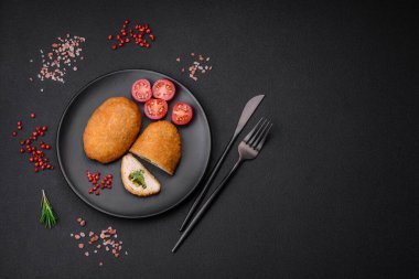 Lezzetli fırınlanmış pirzola, baharatlar, tuz ve otlarla kaplanmış koyu beton bir arka planda.