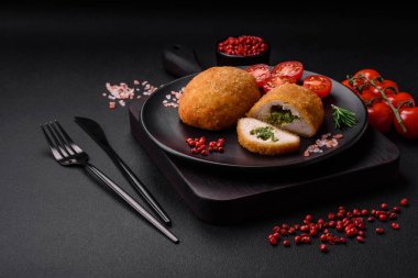 Lezzetli fırınlanmış pirzola, baharatlar, tuz ve otlarla kaplanmış koyu beton bir arka planda.