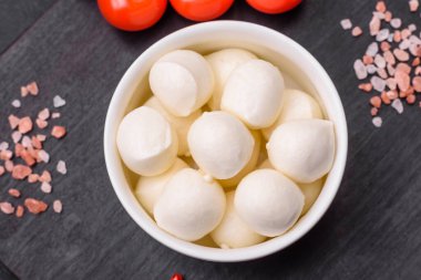 Lezzetli taze mozzarella peyniri. Koyu beton arka planda tuz ve baharat içeren küçük toplar şeklinde.
