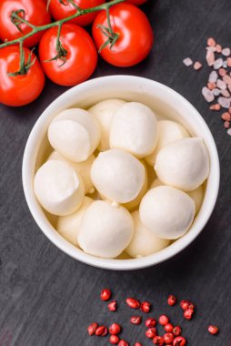Lezzetli taze mozzarella peyniri. Koyu beton arka planda tuz ve baharat içeren küçük toplar şeklinde.
