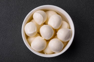 Lezzetli taze mozzarella peyniri. Koyu beton arka planda tuz ve baharat içeren küçük toplar şeklinde.