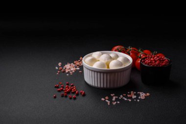 Lezzetli taze mozzarella peyniri. Koyu beton arka planda tuz ve baharat içeren küçük toplar şeklinde.