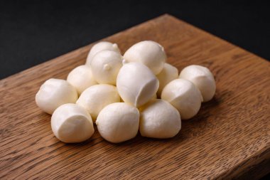 Lezzetli taze mozzarella peyniri. Koyu beton arka planda tuz ve baharat içeren küçük toplar şeklinde.