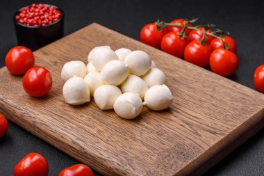 Lezzetli taze mozzarella peyniri. Koyu beton arka planda tuz ve baharat içeren küçük toplar şeklinde.