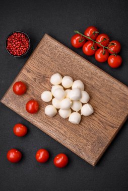 Lezzetli taze mozzarella peyniri. Koyu beton arka planda tuz ve baharat içeren küçük toplar şeklinde.