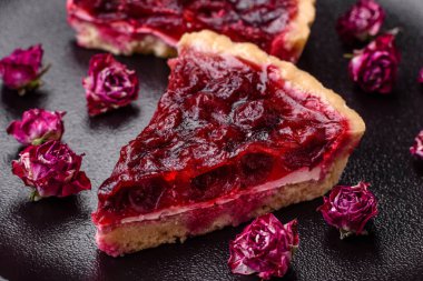 Koyu beton arka planda seramik tabakta kiraz meyveli lezzetli kokulu tatlı turta.