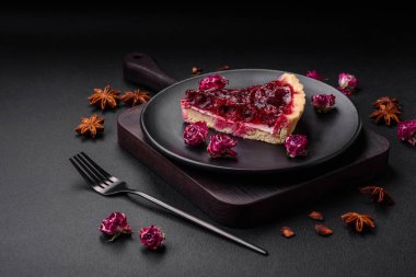 Koyu beton arka planda seramik tabakta kiraz meyveli lezzetli kokulu tatlı turta.