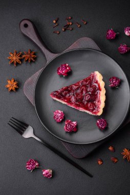 Koyu beton arka planda seramik tabakta kiraz meyveli lezzetli kokulu tatlı turta.