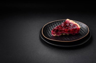 Koyu beton arka planda seramik tabakta kiraz meyveli lezzetli kokulu tatlı turta.