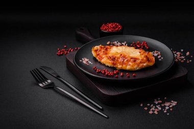 Izgara tavuk filetosu, domatesli biftek, ananas ve peynirli koyu beton arka planda.