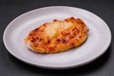 Izgara tavuk filetosu, domatesli biftek, ananas ve peynirli koyu beton arka planda.