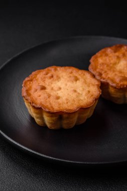 Lezzetli kek ya da peynirli tart ve koyu dokulu arkaplanda kuru üzüm.