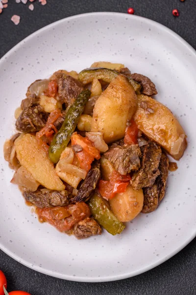 用土豆 西红柿 洋葱和胡萝卜在深色混凝土背景下的陶瓷盘上做的美味炖菜 — 图库照片