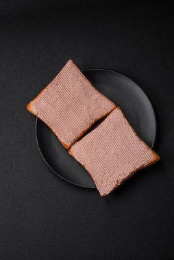 Tavuklu çıtır tost ya da koyu beton arka planda tuzlu ve baharatlı kaz ezmesi.