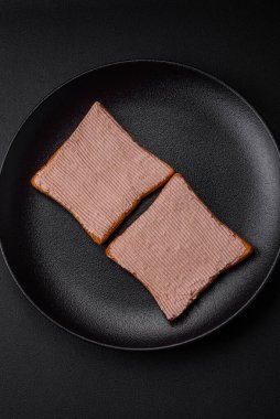 Tavuklu çıtır tost ya da koyu beton arka planda tuzlu ve baharatlı kaz ezmesi.