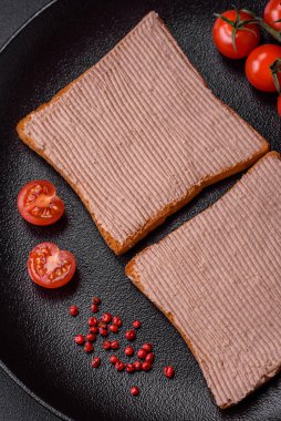 Tavuklu çıtır tost ya da koyu beton arka planda tuzlu ve baharatlı kaz ezmesi.