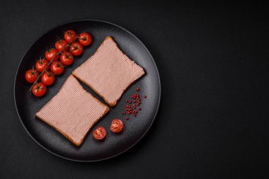Tavuklu çıtır tost ya da koyu beton arka planda tuzlu ve baharatlı kaz ezmesi.
