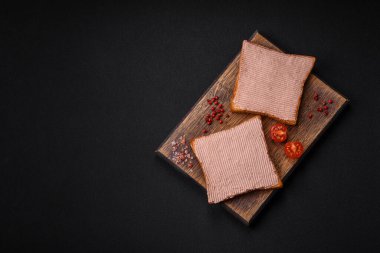 Tavuklu çıtır tost ya da koyu beton arka planda tuzlu ve baharatlı kaz ezmesi.