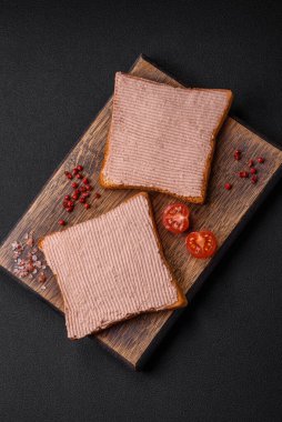 Tavuklu çıtır tost ya da koyu beton arka planda tuzlu ve baharatlı kaz ezmesi.