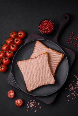 Tavuklu çıtır tost ya da koyu beton arka planda tuzlu ve baharatlı kaz ezmesi.