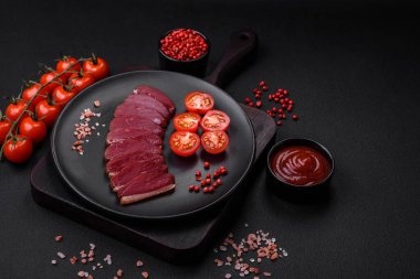 Lezzetli ördek fileto tütsülenmiş ya da baharat ve tuzla kızartılmış koyu beton arka planda.