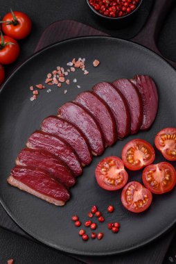 Lezzetli ördek fileto tütsülenmiş ya da baharat ve tuzla kızartılmış koyu beton arka planda.