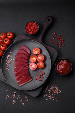 Lezzetli ördek fileto tütsülenmiş ya da baharat ve tuzla kızartılmış koyu beton arka planda.