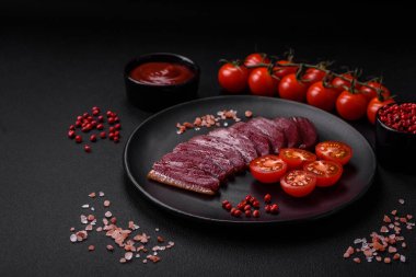 Lezzetli ördek fileto tütsülenmiş ya da baharat ve tuzla kızartılmış koyu beton arka planda.