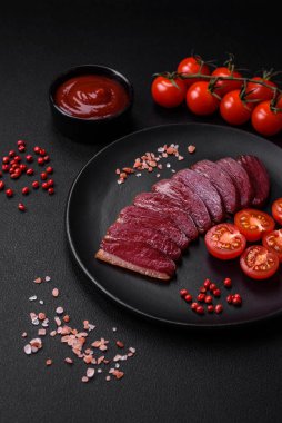 Lezzetli ördek fileto tütsülenmiş ya da baharat ve tuzla kızartılmış koyu beton arka planda.