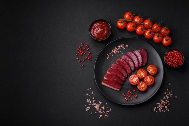 Lezzetli ördek fileto tütsülenmiş ya da baharat ve tuzla kızartılmış koyu beton arka planda.