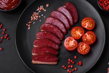 Lezzetli ördek fileto tütsülenmiş ya da baharat ve tuzla kızartılmış koyu beton arka planda.