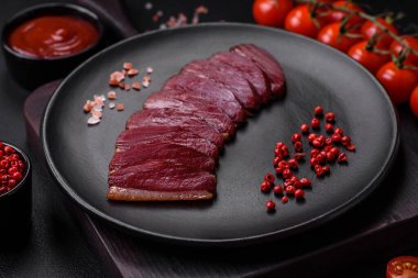 Lezzetli ördek fileto tütsülenmiş ya da baharat ve tuzla kızartılmış koyu beton arka planda.