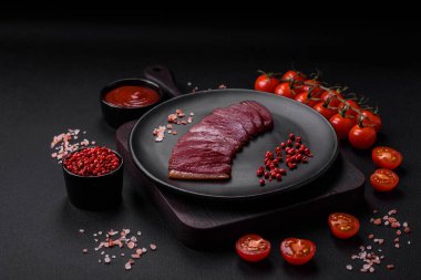 Lezzetli ördek fileto tütsülenmiş ya da baharat ve tuzla kızartılmış koyu beton arka planda.