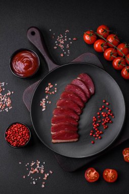 Lezzetli ördek fileto tütsülenmiş ya da baharat ve tuzla kızartılmış koyu beton arka planda.