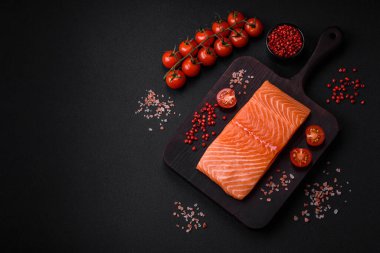 Taze çiğ somon balığı filetosu. Koyu beton arka planda tuz ve baharatla birlikte.