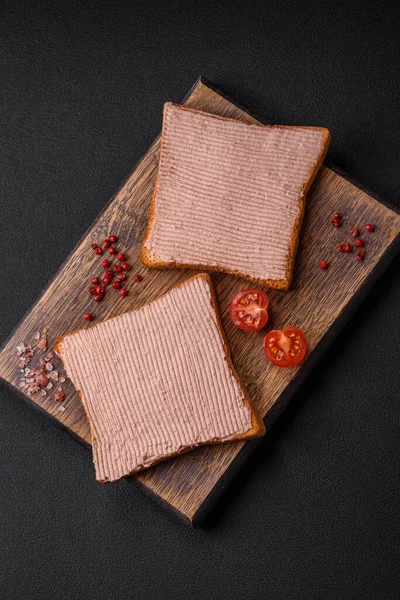 Tavuklu çıtır tost ya da koyu beton arka planda tuzlu ve baharatlı kaz ezmesi.