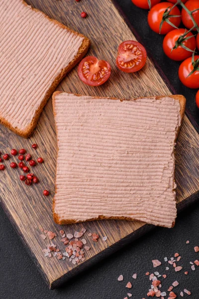 Tavuklu çıtır tost ya da koyu beton arka planda tuzlu ve baharatlı kaz ezmesi.