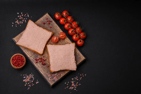Tavuklu çıtır tost ya da koyu beton arka planda tuzlu ve baharatlı kaz ezmesi.