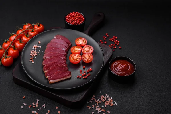 Lezzetli ördek fileto tütsülenmiş ya da baharat ve tuzla kızartılmış koyu beton arka planda.