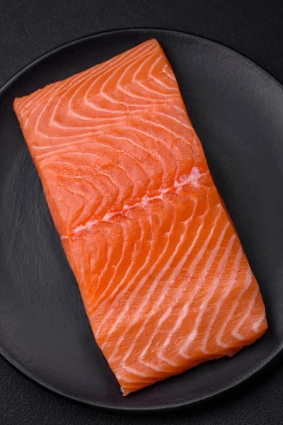 鲜活的生鲑鱼红鱼片 有盐和香料 背景为深色混凝土 — 图库照片